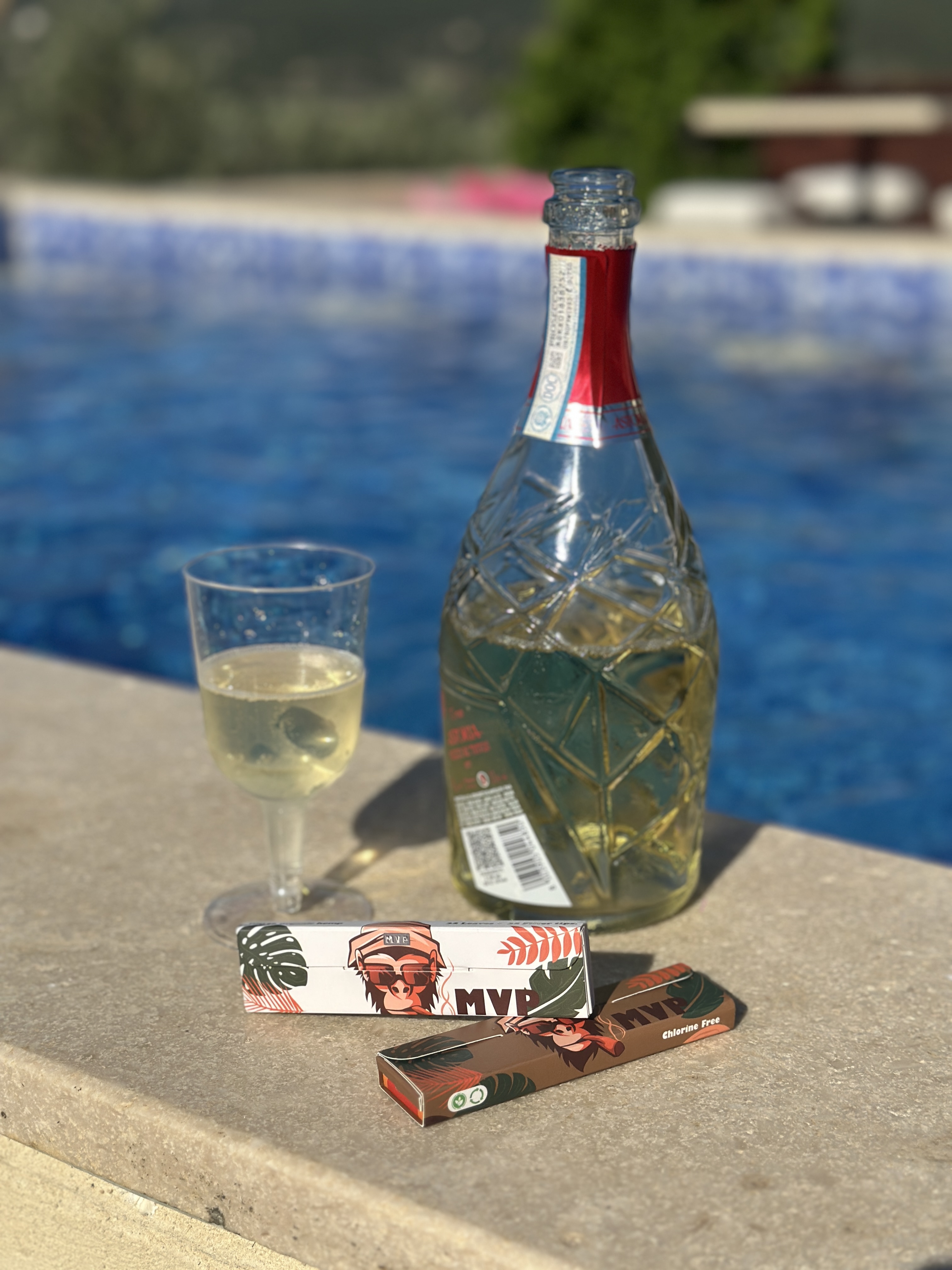 MVP papers beside a drink bottle near a pool